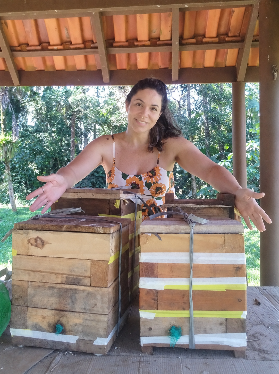 Meliponicultora e artesã do Doce Morretes junto às caixas de abelhas